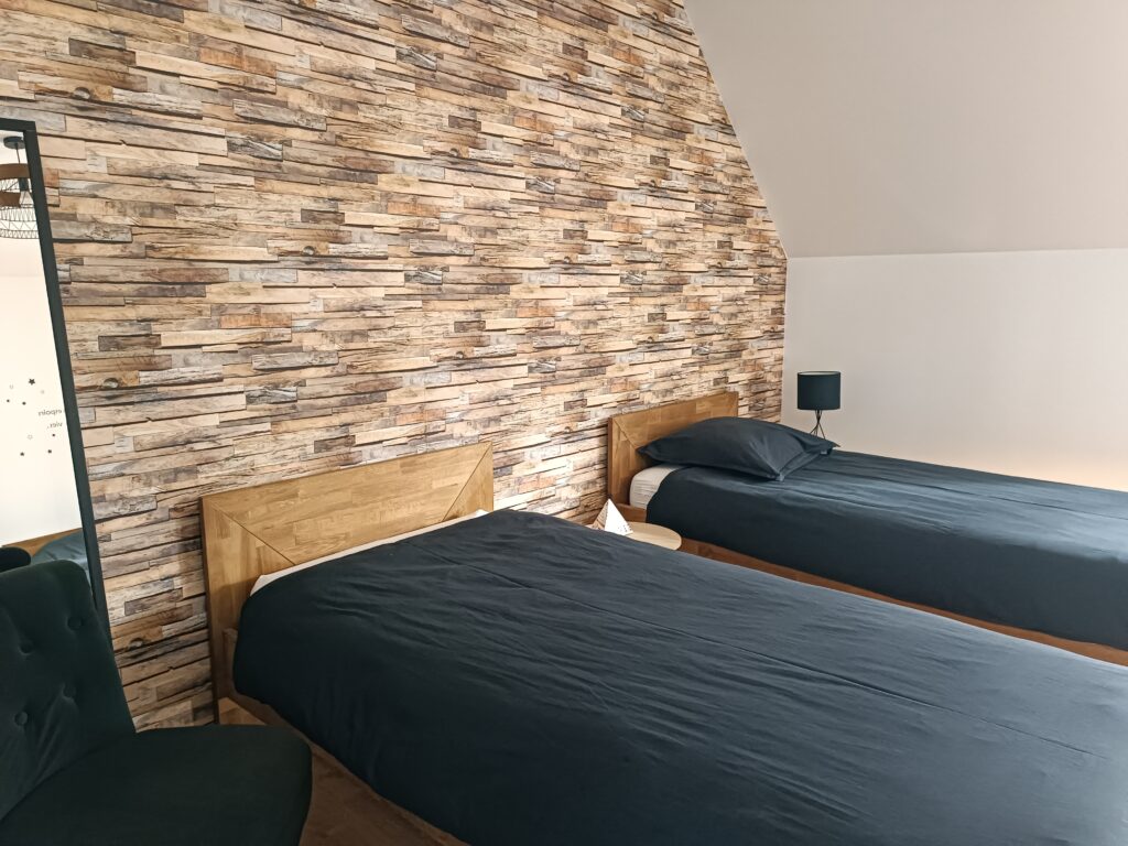 Lits en bois et mur effet pierre dans la chambre La Rêveuse au Bloemstraete