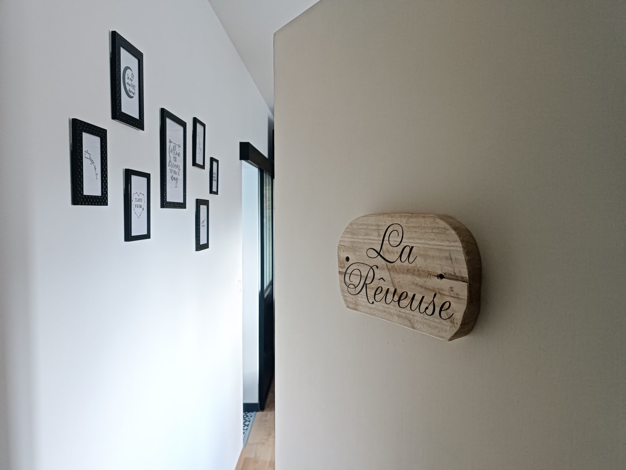 Entrée de la chambre La Rêveuse au Bloemstraete avec plaque en bois et décoration murale