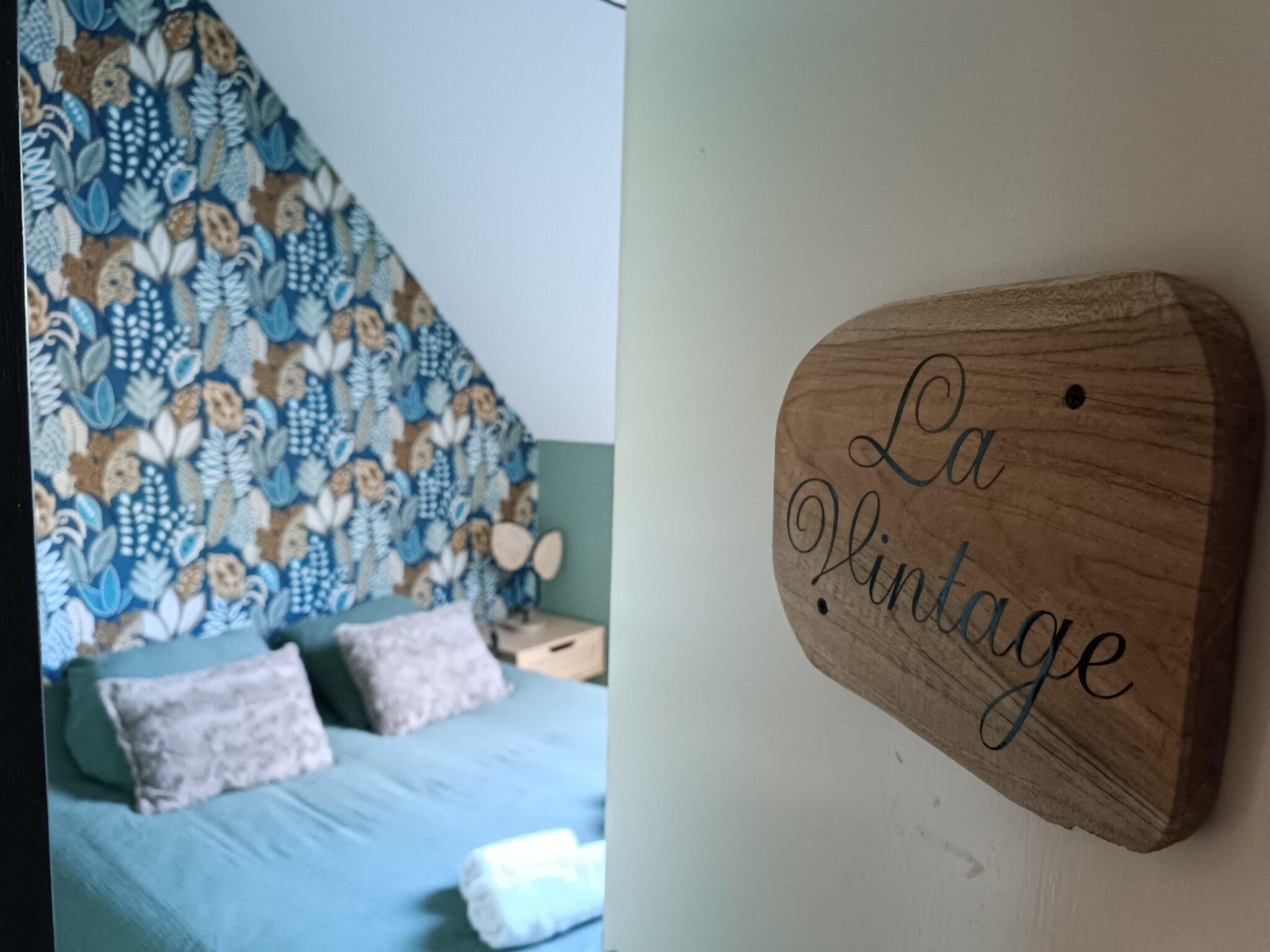 Entrée de la chambre La Vintage au Bloemstraete avec vue sur le lit et sa décoration végétale